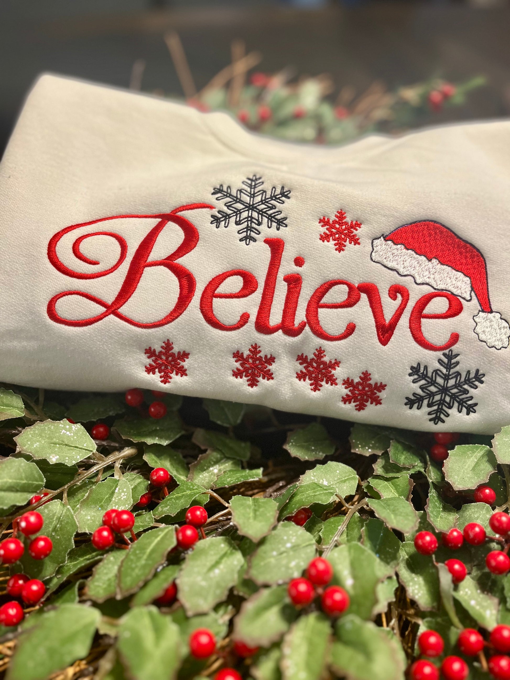 Decorative pillow with 'Believe' text and Santa hat on a Christmas-themed background