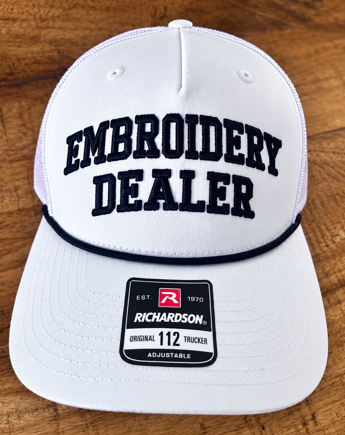 White trucker hat with black Embroidery Dealer embroidery