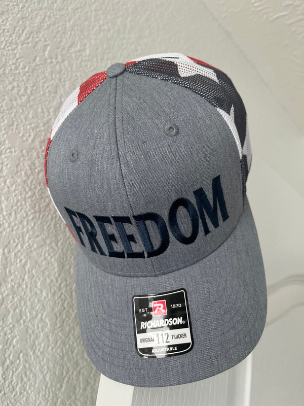 Gray cap with 'FREEDOM' text on a textured surface