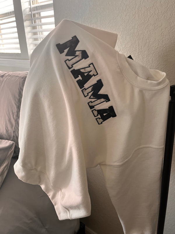 White crewneck sweatshirt with 'MAMA' text in cow print style on the front.
