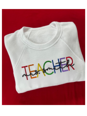 White sweatshirt with 'TEACHER' in colorful letters on a red background