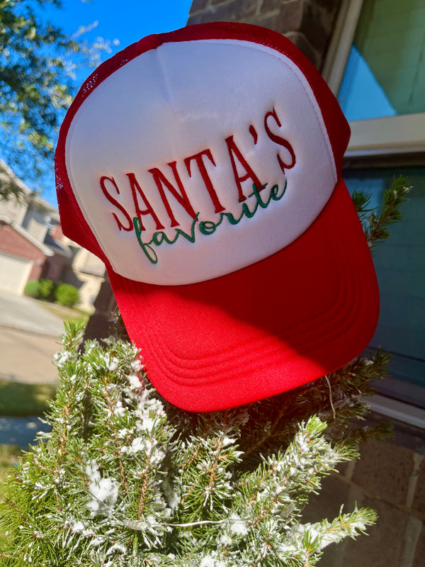 Red and white cap with 'Santa's favorite' text on a Christmas tree.